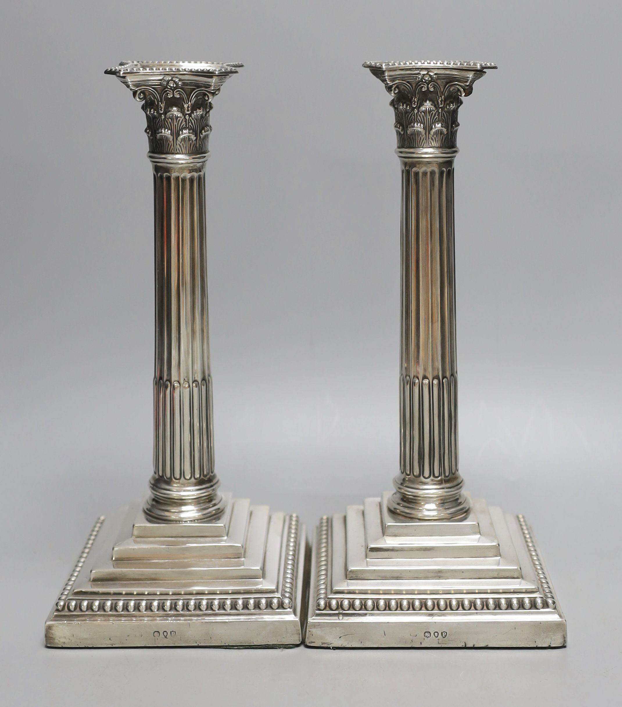 A pair of late Victorian silver Corinthian column candlesticks, maker's mark rubbed, London, 1890, height 27.7cm, weighted.
